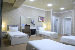a hotel room with three beds in a room at HOBIZ Hotel in Navoi