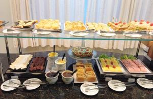 un buffet de diferentes tipos de comida en una mesa en Golden Hotel, en Chapecó