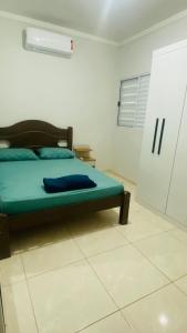 um quarto com uma cama num quarto branco em Casa de Esquina, em Avenida Principal em Três Lagoas