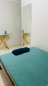 a room with a bed with a blue pillow on it at Casa de Esquina, em Avenida Principal in Três Lagoas