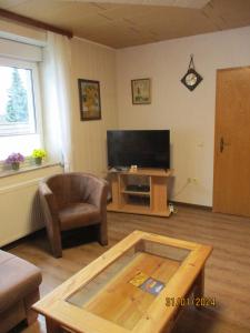 a living room with a coffee table and a television at Ferienwohnung Janne in Fürstenberg