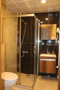 a bathroom with a shower with a toilet and a sink at Center Room Otel in Yenimahalle +18 photos