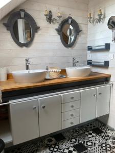 deux lavabos dans une salle de bain avec des miroirs au mur dans l'établissement La Maison Bizienne Guérande - Chambres d'hôtes de charme, à Guérande 82 autres photos