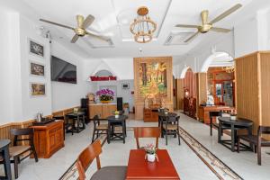 a restaurant with tables and chairs in a room at Le's Apartment & Coffee in Danang