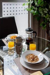 una mesa con dos platos de comida y zumo de naranja en Castle Haven Apartment Redhill, en Redhill