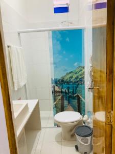a bathroom with a toilet and a view of the water at Sacavem Flat Hotel Navegantes in Navegantes