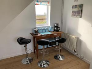a room with a table and two bar stools at 1 Bedroom annex, private bathroom, peaceful area in Claypits