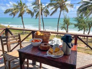 a table with a plate of food on the beach at Verano House BF in Baía Formosa