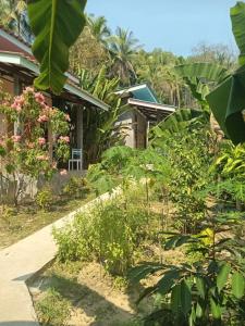 una casa en medio de un jardín en Chom Suan Farmstay en Ko Kood