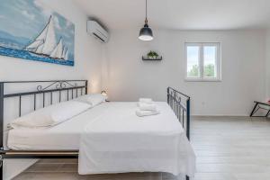 - une chambre avec un lit blanc et un voilier sur le mur dans l'établissement Sweet Coral, à Podglavica 53 autres photos