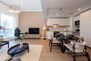 a living room with a kitchen and a dining room at Exclusive Newly Renovated 1BR full Marina views in Dubai +11 photos