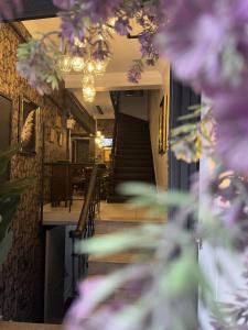 un pasillo con escaleras y flores púrpuras en un restaurante en Perazre Hotel en Estambul