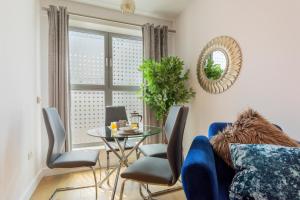 a living room with a blue couch and a table at Queens Lodge 1-Bed Apartment in Redhill in Redhill