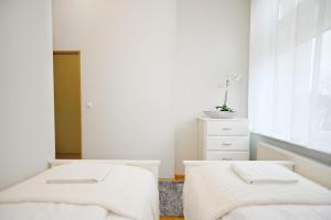deux lits dans une chambre blanche avec une fenêtre dans l'établissement Victus Apartamenty, Apartament Tuż Przy Plaży, à Sopot