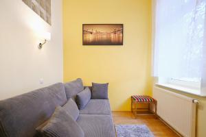 - un salon avec un canapé gris et une fenêtre dans l'établissement Victus Apartamenty, Apartament Tuż Przy Plaży, à Sopot