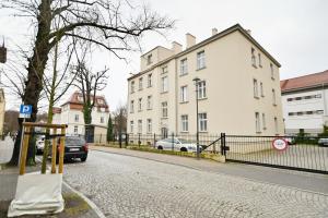 une voiture est garée dans une rue à côté d'un bâtiment dans l'établissement Victus Apartamenty, Apartament Tuż Przy Plaży, à Sopot