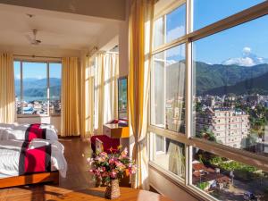 una camera da letto con una grande finestra con vista sulla città di Hotel City Inn - Mountain View a Pokhara