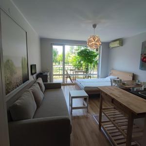 uma sala de estar com um sofá e uma mesa em HOLIDAY ORCHID FORT GARDEN - Premium Apartments em Sunny Beach