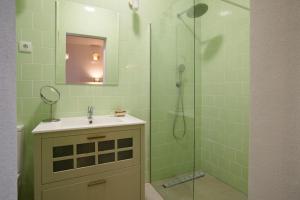 um banheiro com pia e chuveiro com espelho em Tavira Loft Almirante Design em Tavira mais 9 fotografias