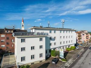 ein weißes Gebäude mit einem Uhrturm im Hintergrund in der Unterkunft Hotel Mary in Vicenza