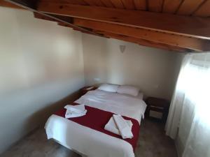a bedroom with a bed with white sheets and red blanket at Dove Apart Hotel in Fethiye