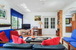 sala de estar con sofá azul y almohadas rojas en Villa Corrib, en Santa Fe de los Boliches