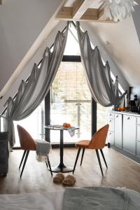 una cucina con tavolo e sedie in una stanza di Alpina Residence & Kameralne SPA a Bukowina Tatrzańska