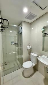 uma casa de banho com um chuveiro, um WC e um lavatório. em Apartemen Podomoro View Kota 2BR lantai 17 Full perabot em Medan