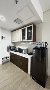uma cozinha com um frigorífico preto num quarto em Apartemen Podomoro View Kota 2BR lantai 17 Full perabot em Medan