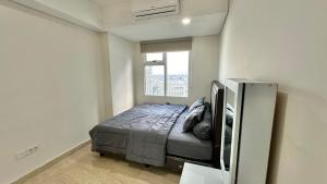 um quarto com uma cama num quarto com uma janela em Apartemen Podomoro View Kota 2BR lantai 17 Full perabot em Medan