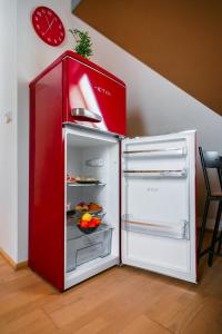 czerwona lodówka z otwartymi drzwiami z jedzeniem wewnątrz w obiekcie Apartmán ve vile w Ostravie