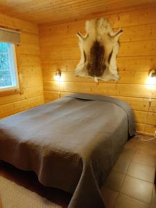a bedroom with a bed in a wooden cabin at Himos Slalom 1, Poreallas kuuluu hintaan in Jämsä