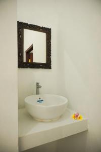 La salle de bains est pourvue d'un lavabo et d'un miroir mural. dans l'établissement Kim Homestay, à Ubud