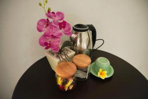 - une table avec une cafetière et des fleurs dans l'établissement Kim Homestay, à Ubud