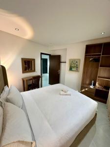 um quarto com uma grande cama branca num quarto em Appart Neuf Lumineux Climatisé 1ère étage em Tânger