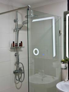 y baño con ducha y puerta de cristal. en Appart Neuf Lumineux Climatisé 1ère étage, en Tánger
