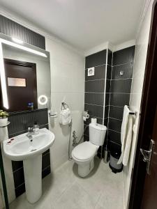een badkamer met een wit toilet en een wastafel bij Appart Neuf Lumineux Climatisé 1ère étage in Tanger