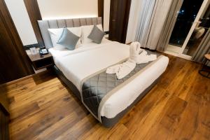 duże łóżko w pokoju z drewnianą podłogą w obiekcie Hotel Le Grandeur w mieście Narasimharaja Puram