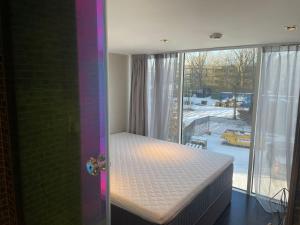 een slaapkamer met een bed in een kamer met een raam bij Diamond Capsule Hotel Amsterdam South in Amstelveen