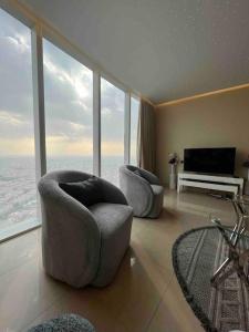 sala de estar con 2 sillas y TV en شقة في برج رافال بإطلالة ساحره en Riad