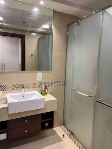 y baño con lavabo y ducha. en شقة في برج رافال بإطلالة ساحره en Riad