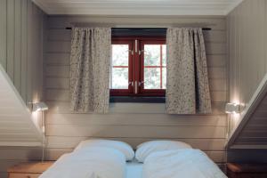 a bedroom with a bed and a window at Hunderfossen Apartments in Hafjell