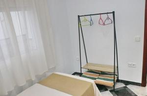 コニル・デ・ラ・フロンテーラにあるApartamento Santa Ritaのベッドルーム1室(ベッド1台、洋服ラック、ハンガー付)