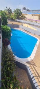 una gran piscina azul en la parte lateral de un edificio en CANDELARIA SOL Y MAR en Candelaria