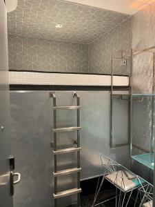 a bunk bed in a room with a ladder at Diamond Capsule Hotel Amsterdam South in Amstelveen