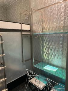 a bunk bed with a glass table and a chair at Diamond Capsule Hotel Amsterdam South in Amstelveen