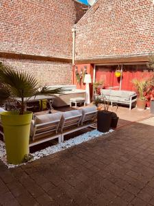 um pátio com sofás e plantas num edifício de tijolos em Studio indépendant et calme avec Jacuzzi à Lille em Lille