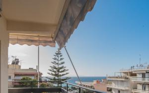 a view of the ocean from the balcony of a building at Valeria's Sea View Apartment in Athens