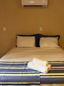 uma cama com duas toalhas em cima em Chalé Maria Bonita - Ilha Grande, RJ em Angra dos Reis