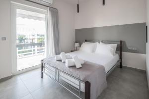 a bedroom with a large bed and a large window at Valeria's Sea View Apartment in Athens